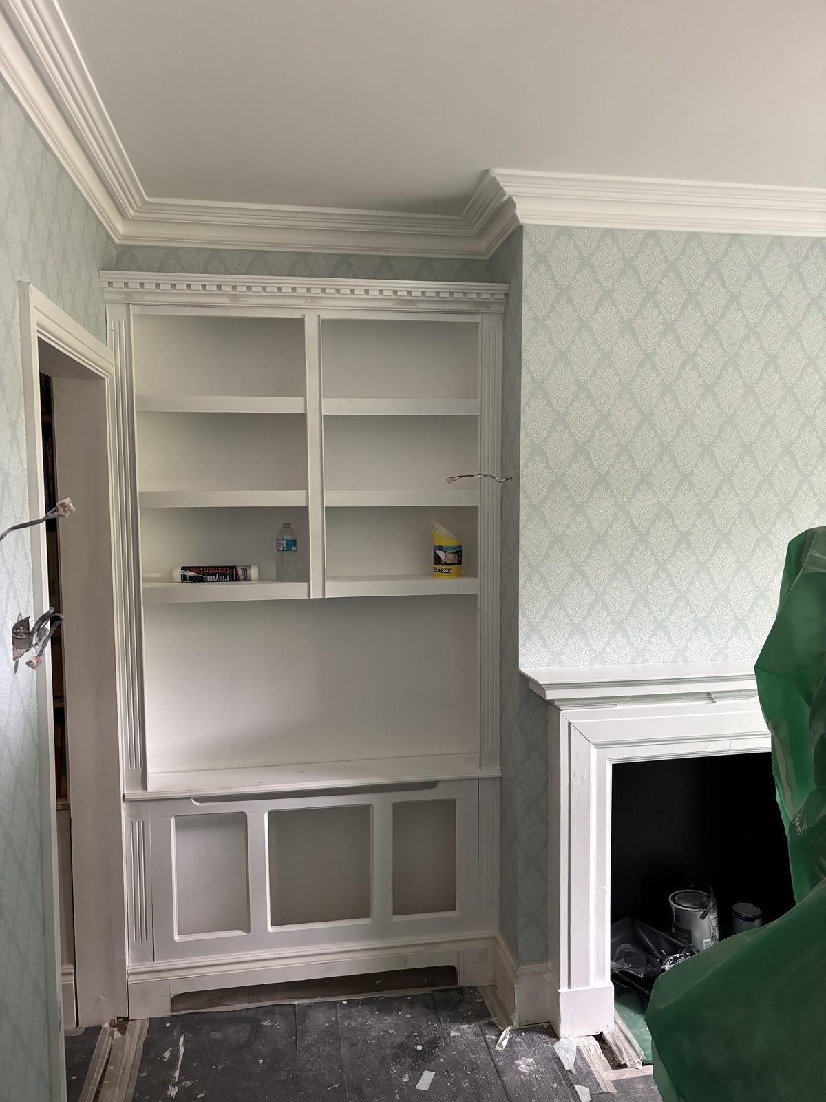 Wallpaper and coving around fitted shelving